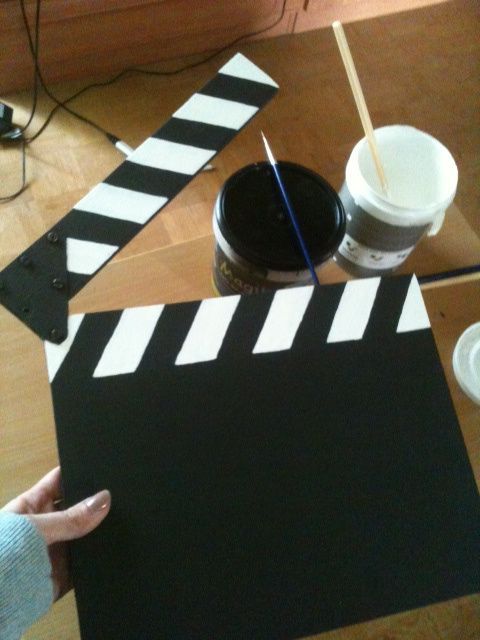 someone is making a movie strip out of construction paper and paint the film strip black