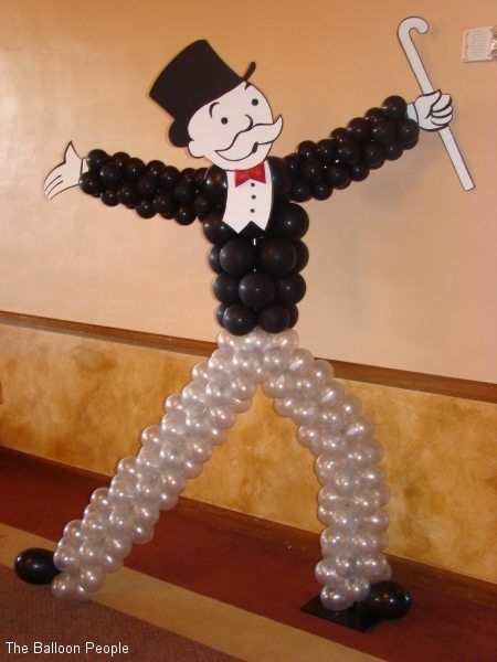 the balloon man is holding an umbrella and wearing a top hat while standing in front of a wall