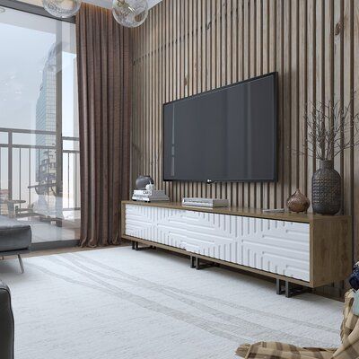 a large flat screen tv sitting on top of a wooden entertainment center in a living room