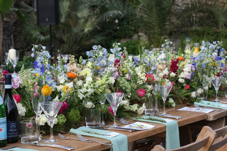 a long table with flowers and wine glasses on it