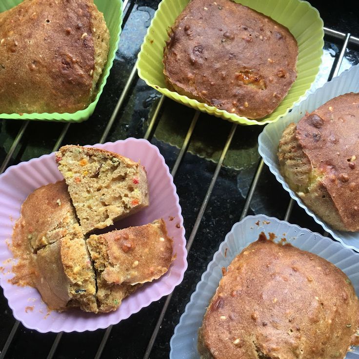 several muffins cooling on the grill with paper plates full of them and one cut in half