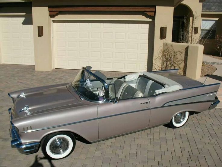 an old car parked in front of a house