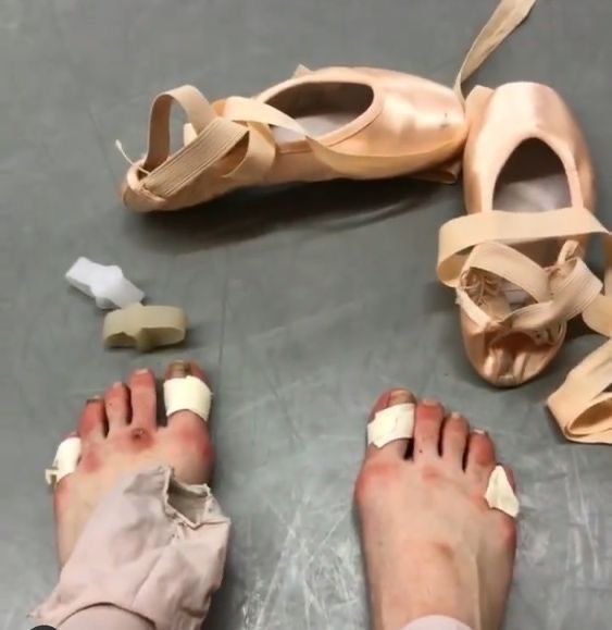 a person with their feet on the ground next to ballet shoes and shoelaces