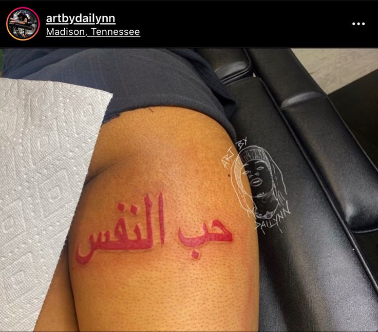 a person with arabic writing on their arm