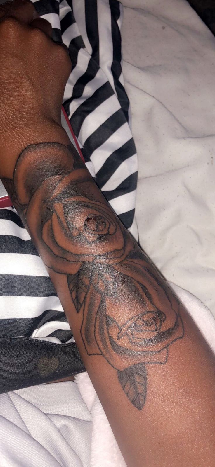 a man's arm with a rose tattoo on it