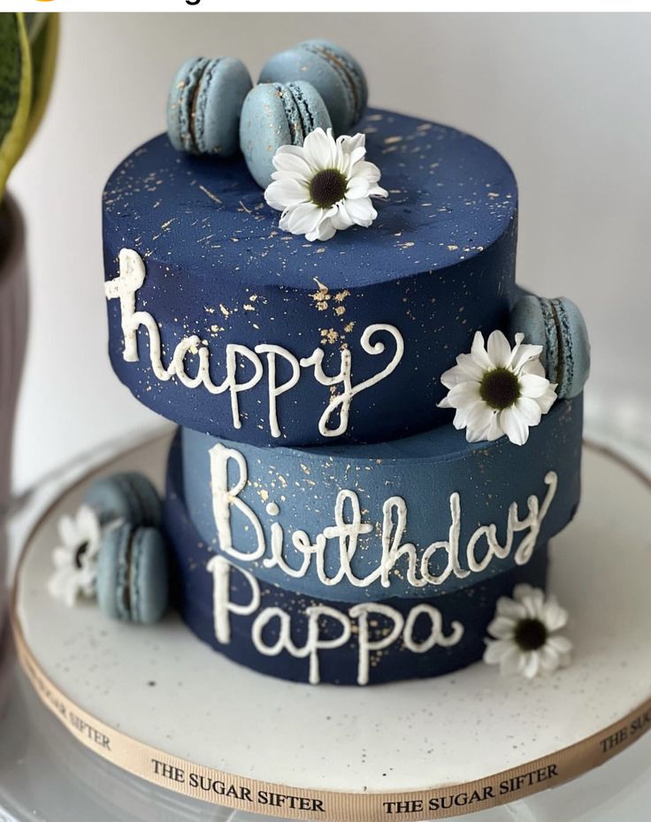 a blue birthday cake with white flowers on top and the words happy birthday papa written on it