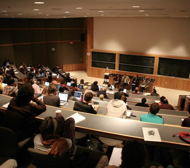 an auditorium full of people with laptops