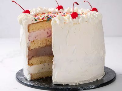 a cake with white frosting and colorful sprinkles on top is cut in half