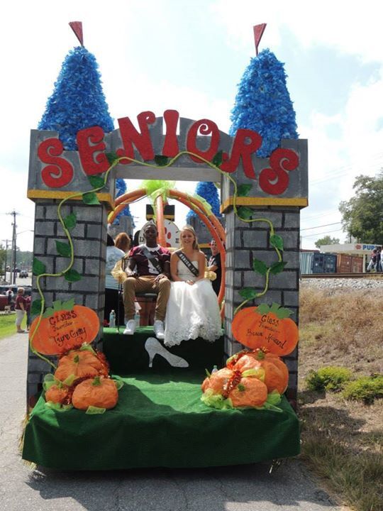 a group of people sitting on top of a fake brick structure with decorations around it