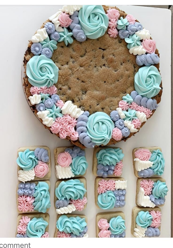 a cookie decorated with blue, pink and white icing on top of a table