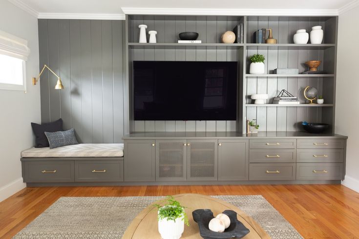 a living room filled with furniture and a flat screen tv on top of a wooden table