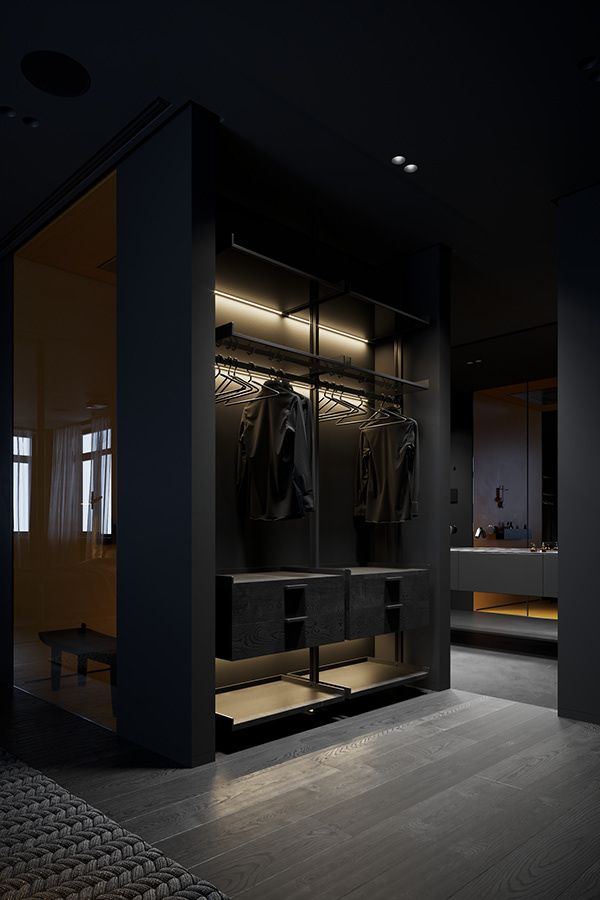 an empty walk in closet with clothes hanging on the walls and lights above it at night