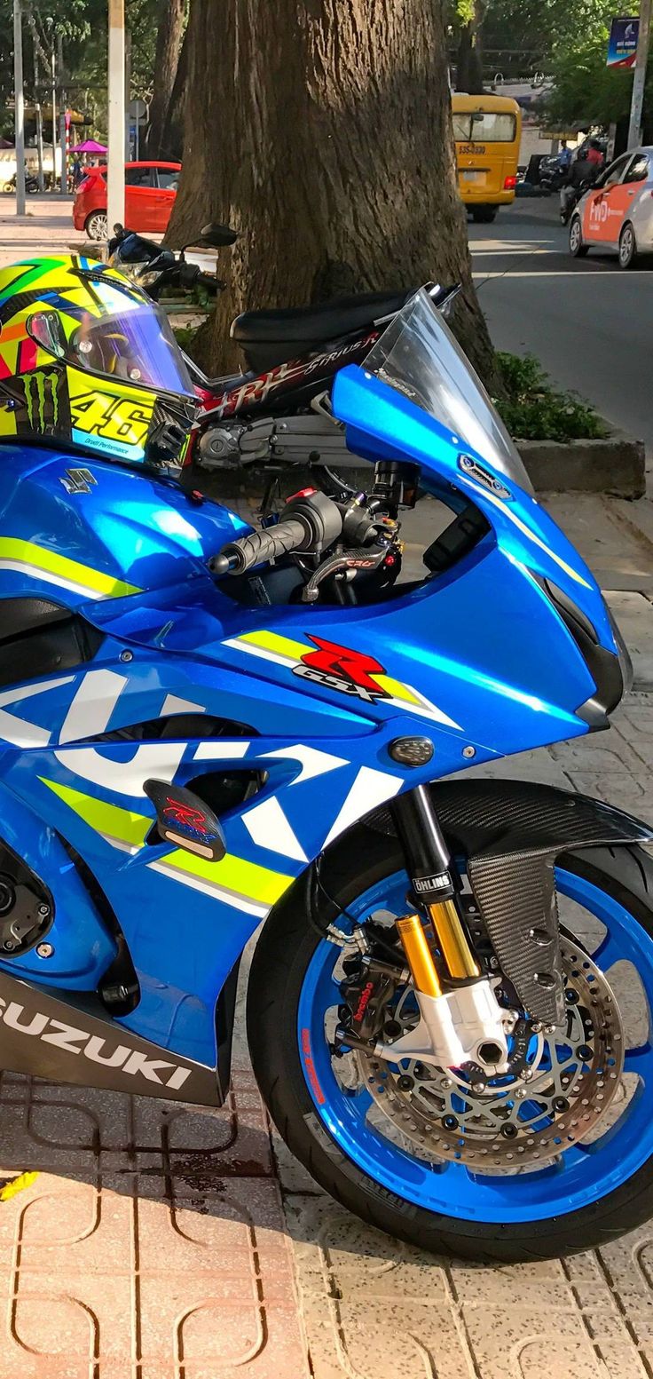 a blue motorcycle parked next to a tree