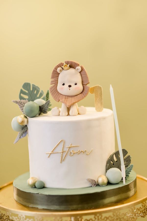 a white cake with a lion on top and decorations around the edges that says aforn