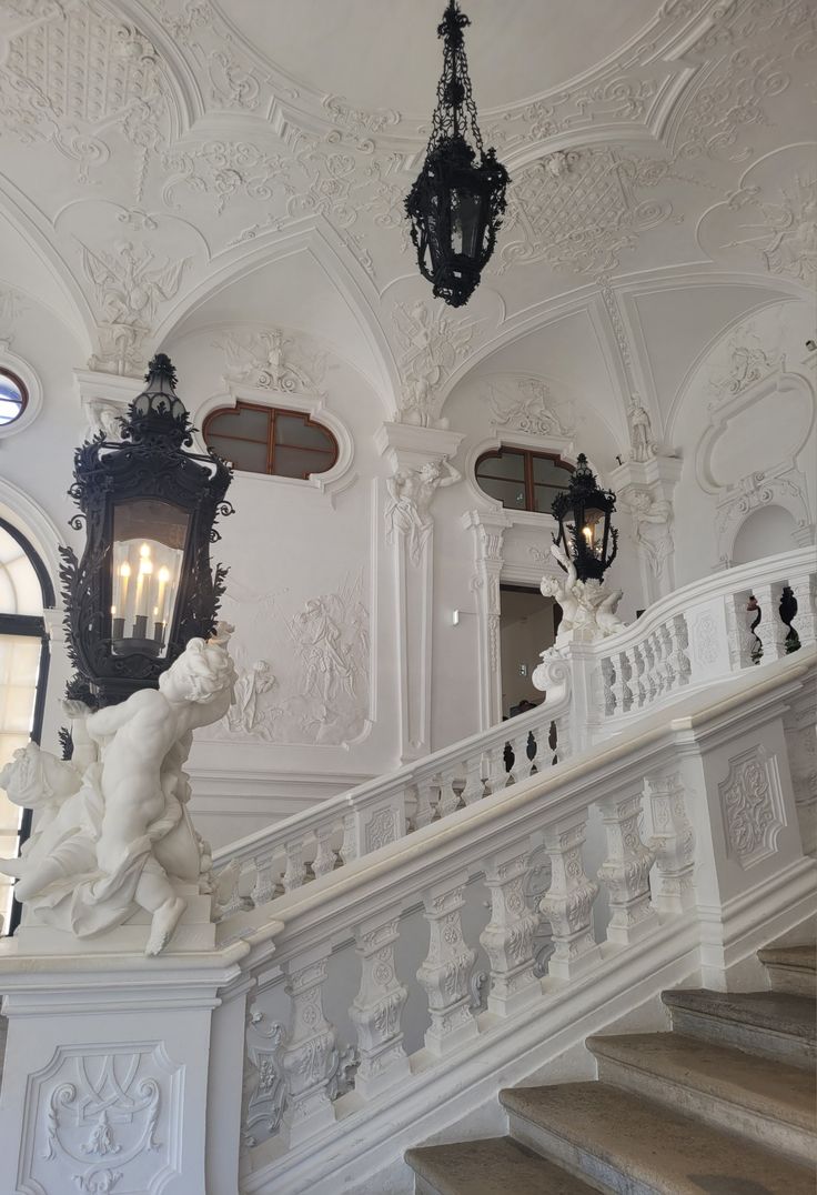 an ornate staircase with statues and chandeliers