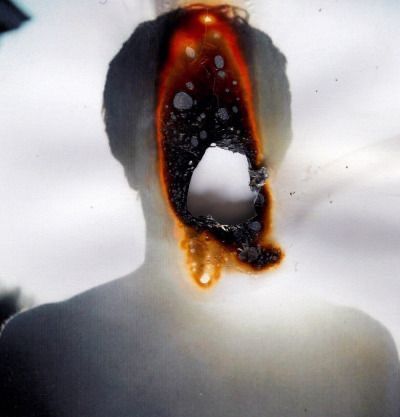 a woman's face is covered in orange and black liquid as she stands with her mouth open