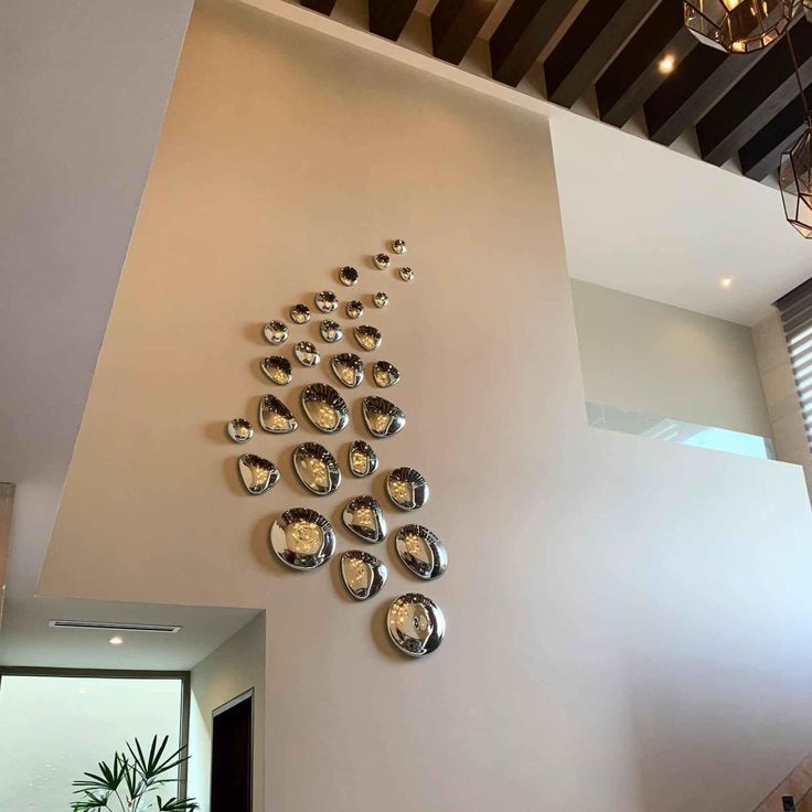 the wall is decorated with silver plates and hanging from it's ceiling, along with a chandelier