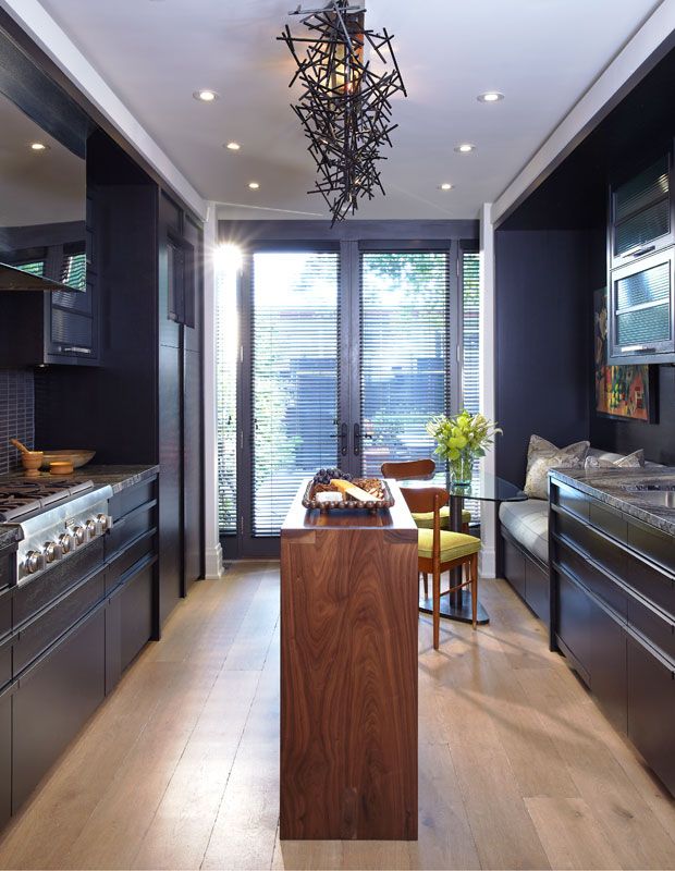 a kitchen with black walls and wooden floors