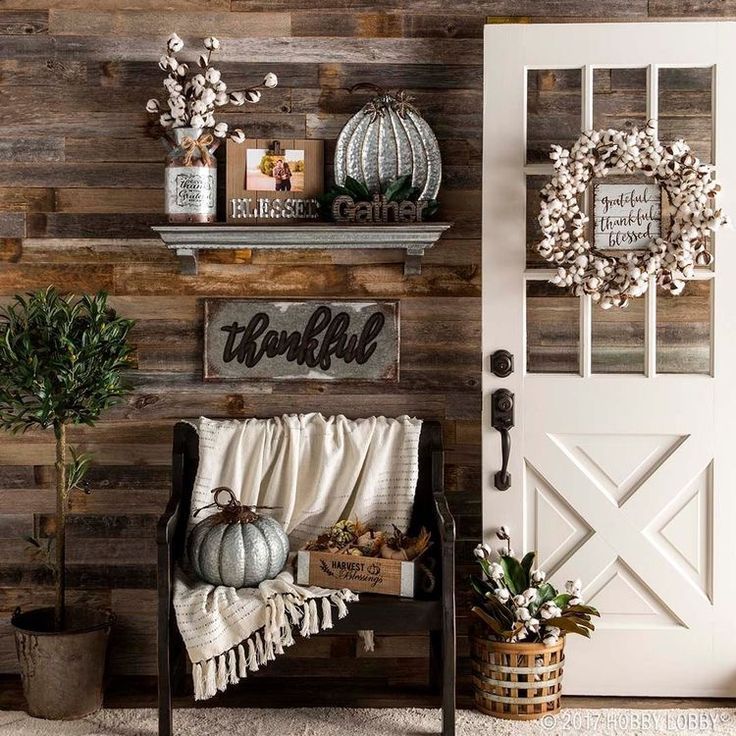 a wooden wall with some pumpkins and other decorations on it's shelf next to a white door