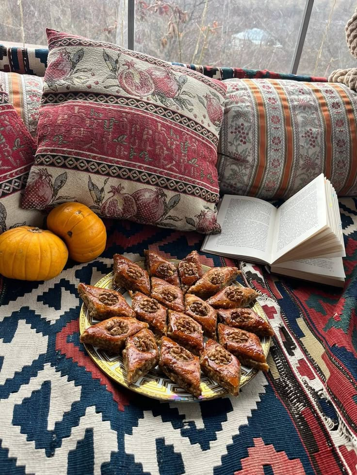 a plate of food sitting on top of a table next to pillows and pumpkins