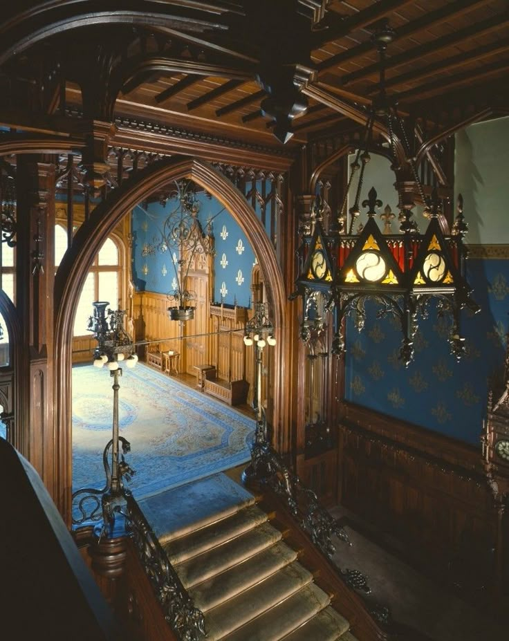 an ornately decorated building with blue walls and wooden floors, chandeliers and stained glass windows