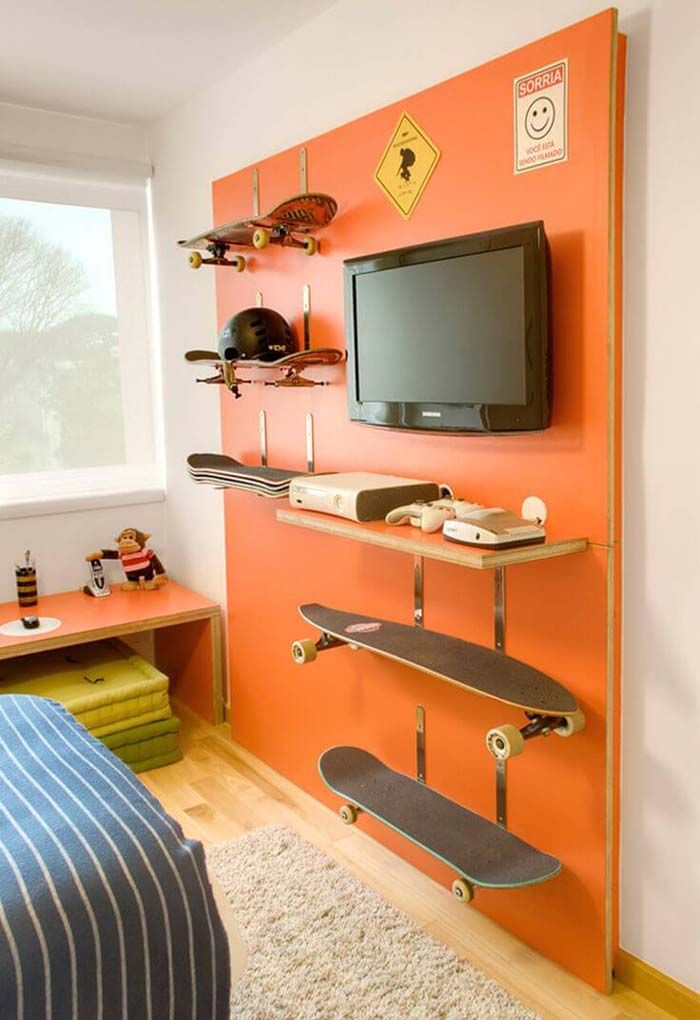 a bedroom with orange walls and skateboards mounted to the wall, along with a television