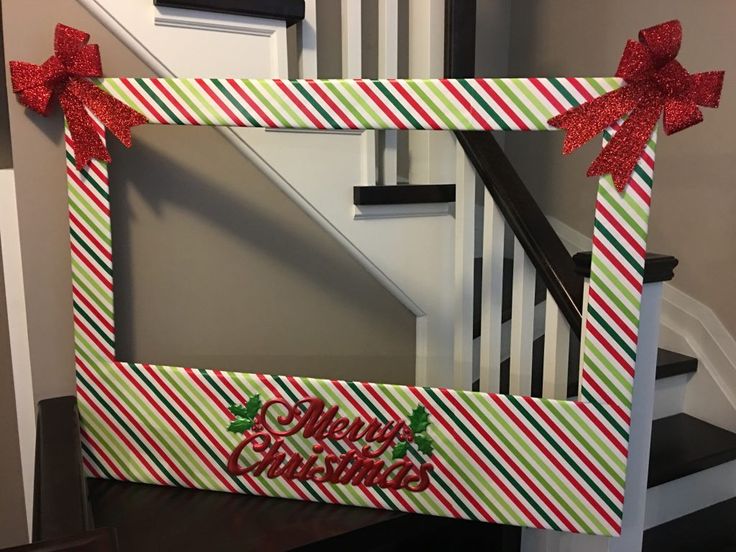 a decorated christmas frame sitting on top of a table next to a stair case and banister