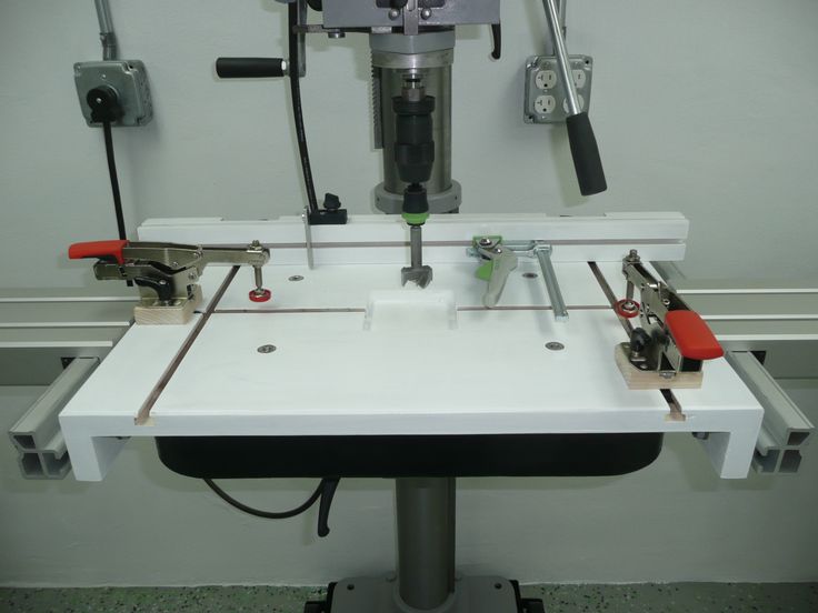 a machine that is sitting on top of a white table with tools attached to it