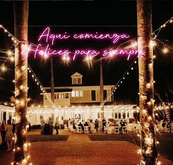 an event with lights and palm trees in front of the building that says agui conversa felices para sempres