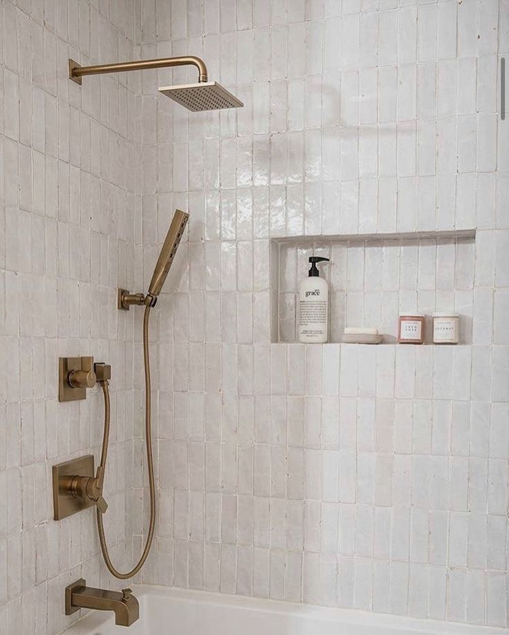 a bathroom with a tub, shower head and hand held faucet