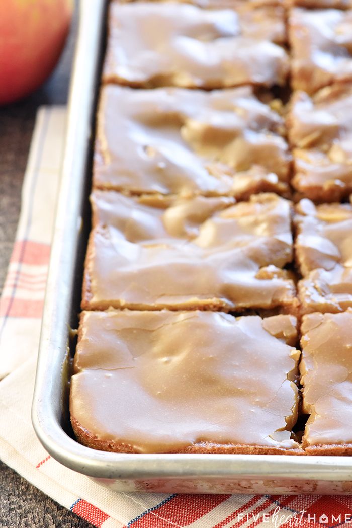 a pan filled with frosted brownies next to an apple