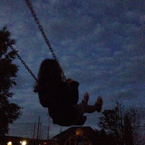 a person swinging on a swing at night