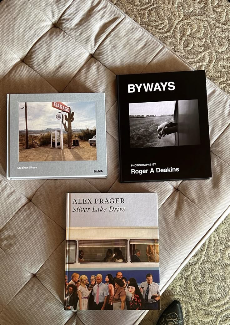 three books sitting on top of a bed next to each other