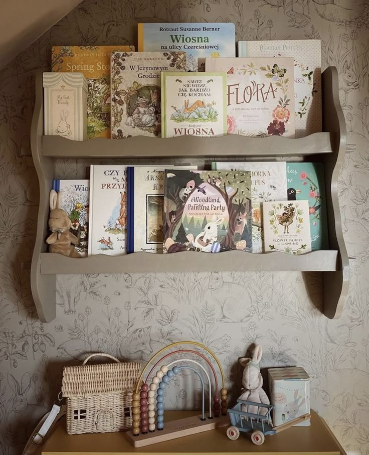 there are many children's books on the shelves above the dresser in this room