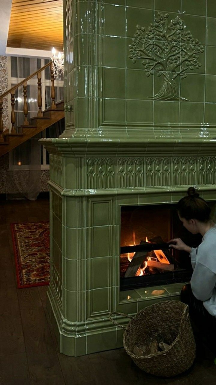 a woman kneeling down in front of a fireplace