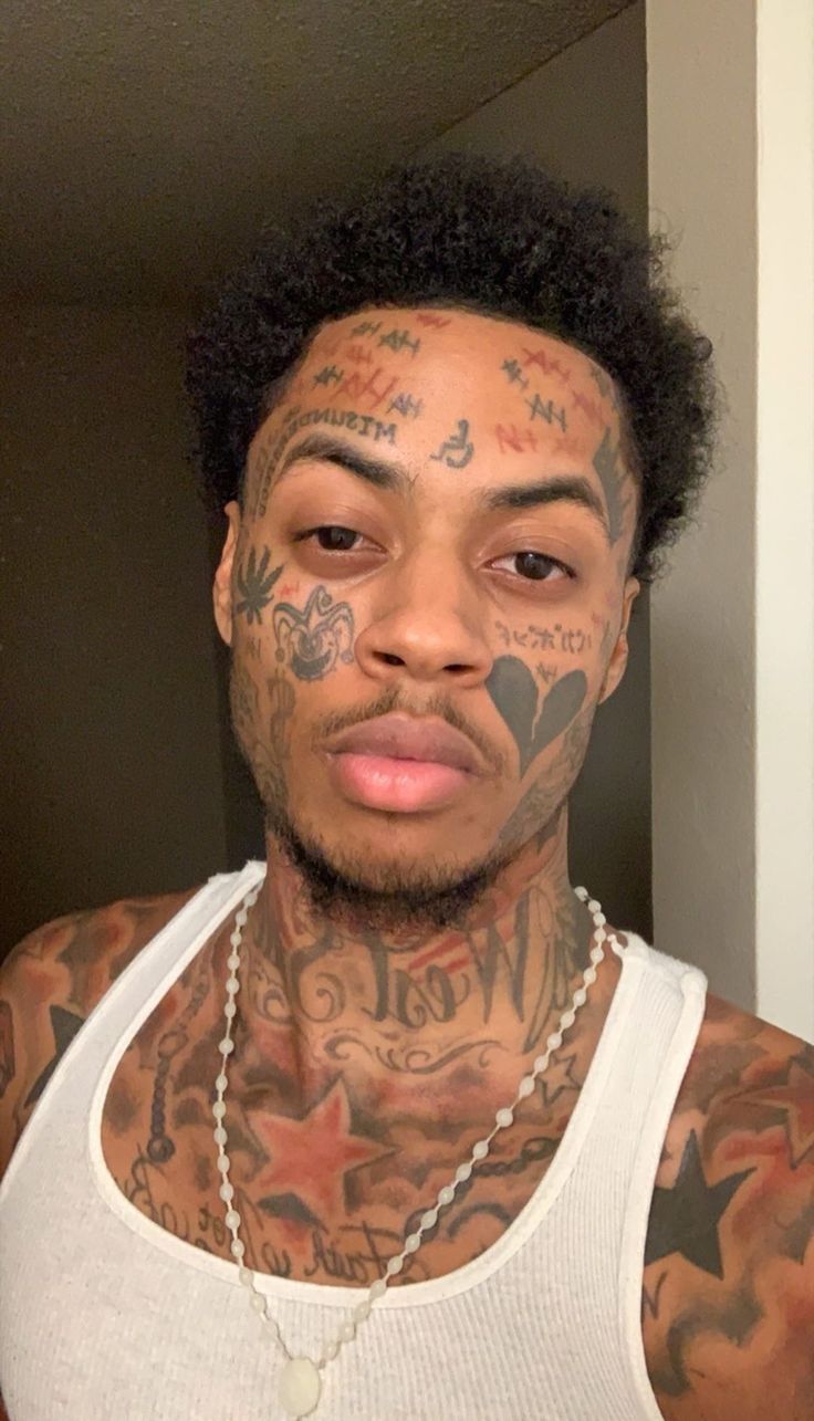 a man with tattoos on his face and chest