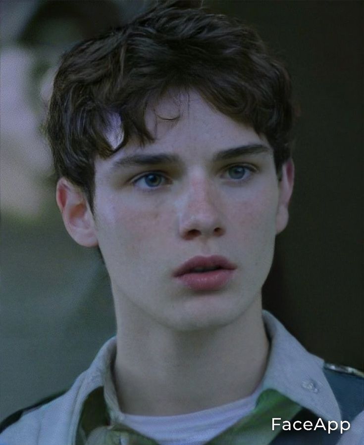 a young man with blue eyes stares into the camera