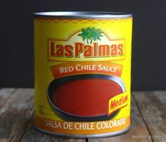 a can of red chile sauce sitting on top of a wooden table