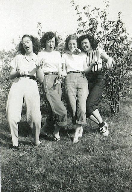 three women standing next to each other in the grass