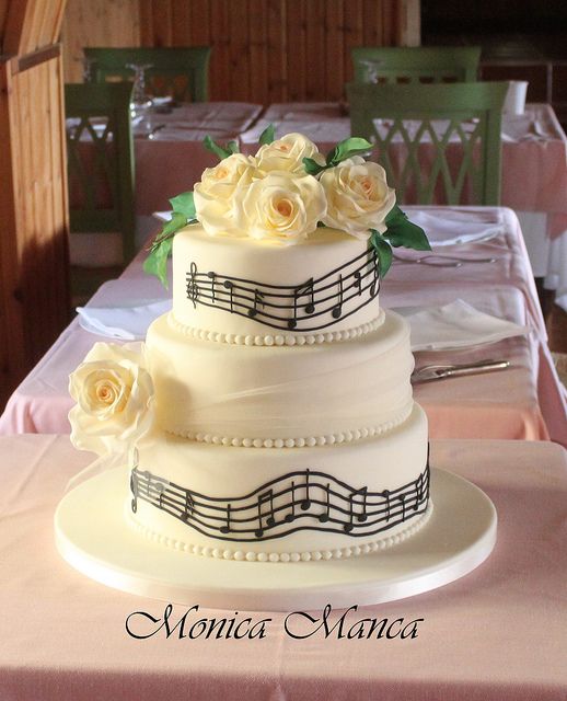 a wedding cake with musical notes and roses on the top is ready to be eaten