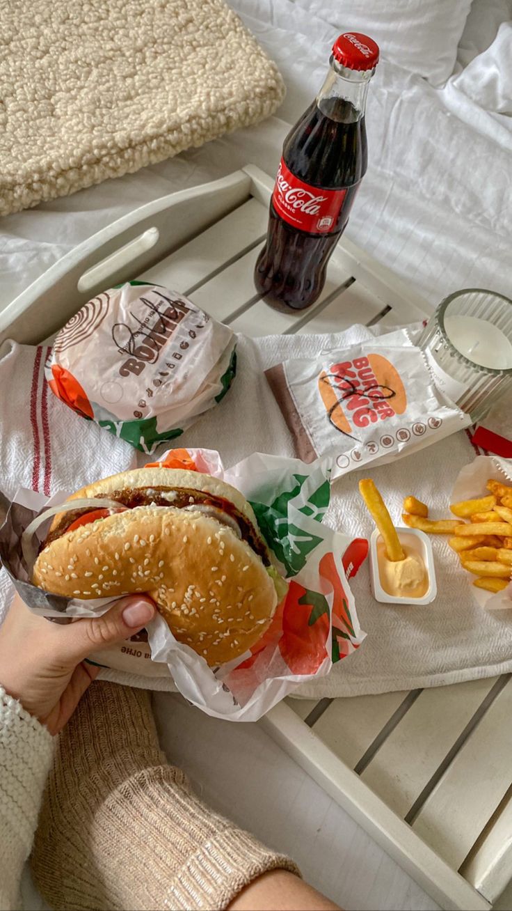 a person holding a hot dog and french fries