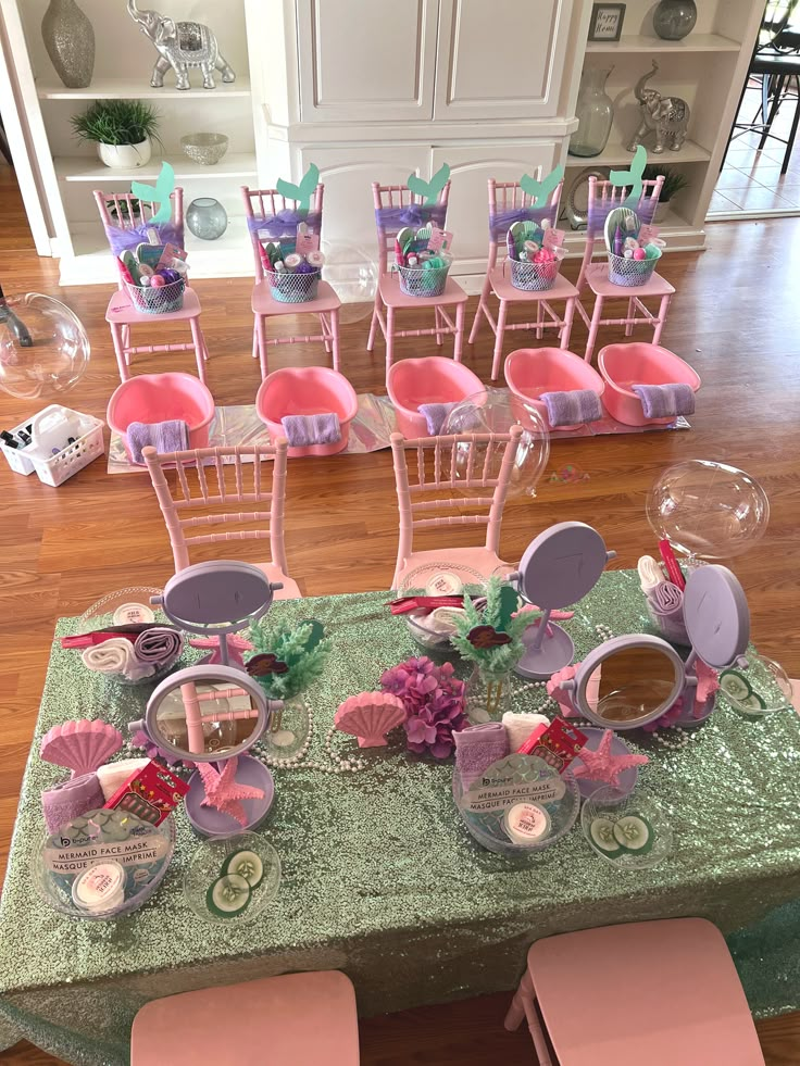 a table set up with pink chairs and plates