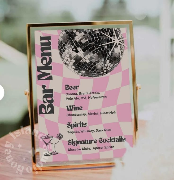 a pink and white menu sitting on top of a wooden table