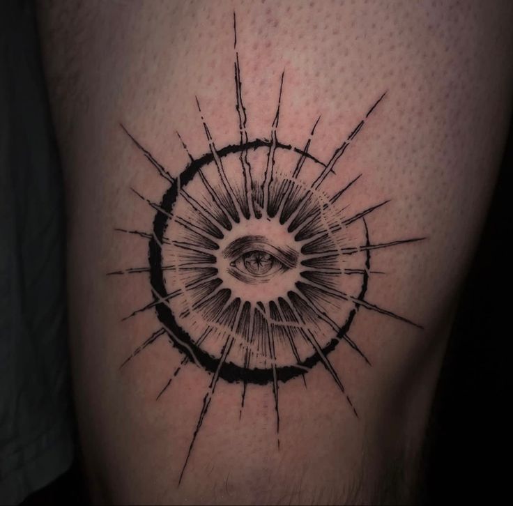 a black and white tattoo with an all seeing eye on the side of a man's leg