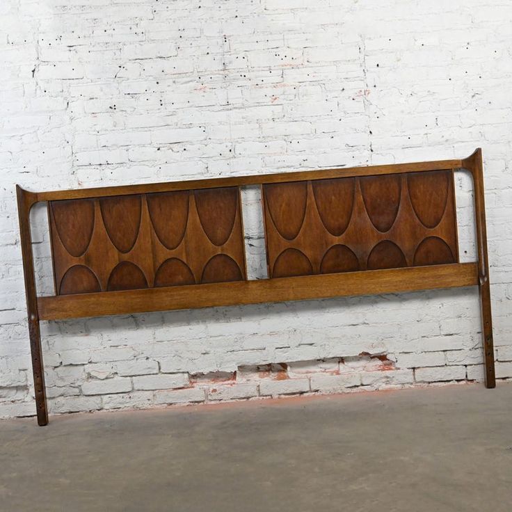 a wooden bench sitting in front of a white brick wall