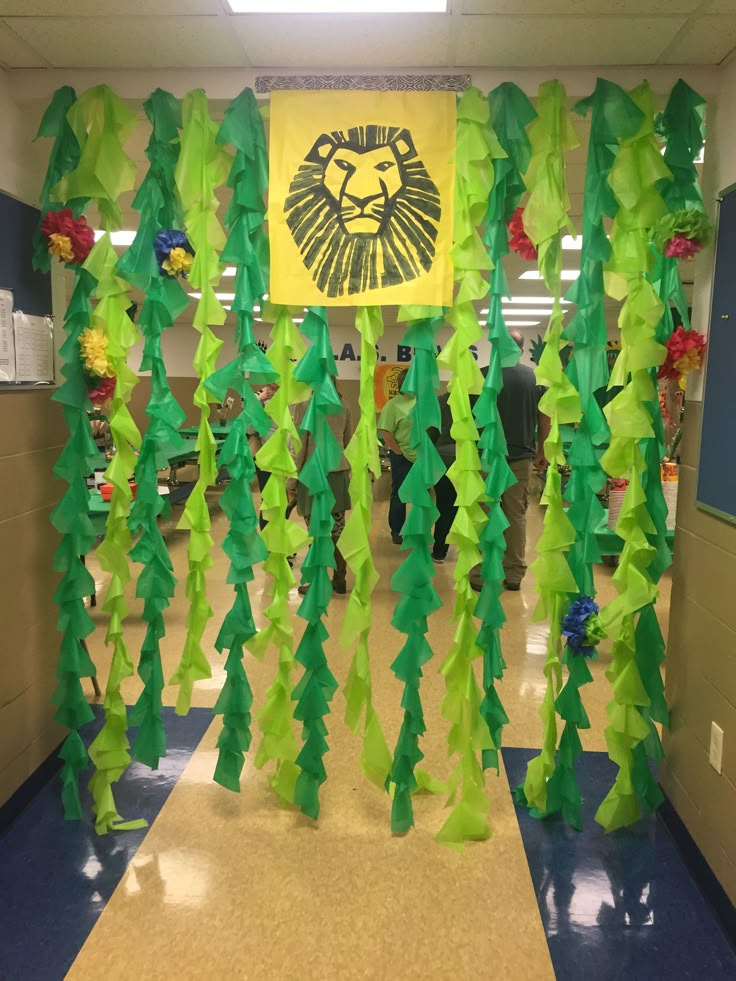 a hallway decorated with green and yellow paper streamers that have been cut into the shape of trees