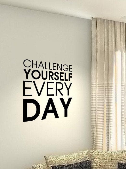 a living room filled with furniture and a quote on the wall above it that says challenge yourself every day