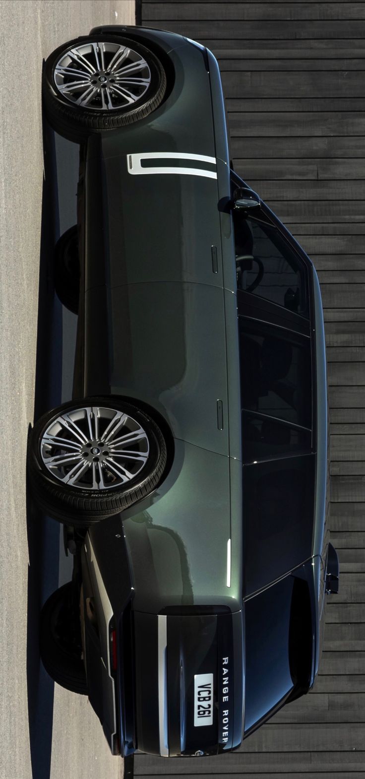 two cars parked next to each other in front of a garage door with one car upside down