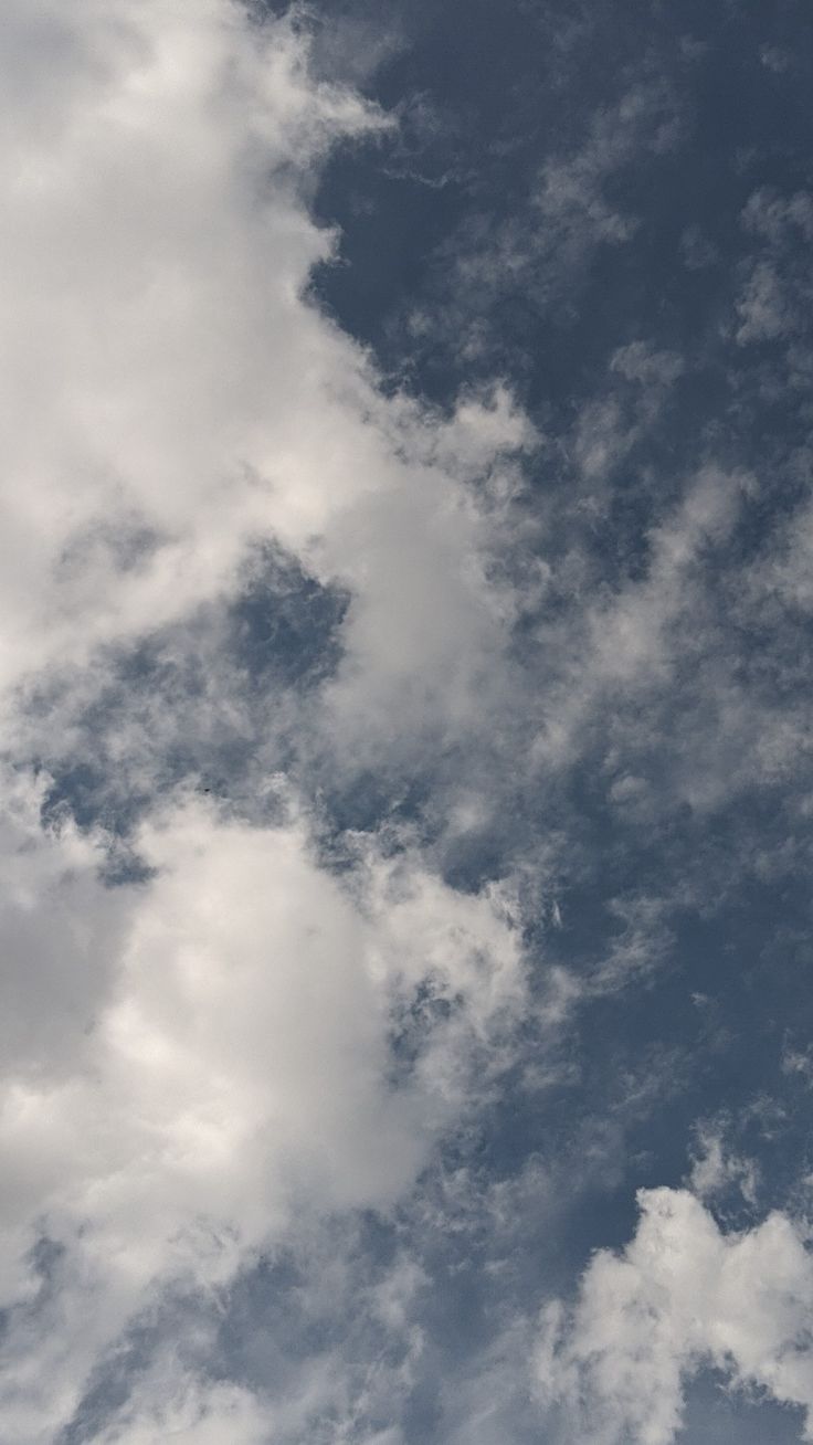 an airplane is flying through the cloudy sky