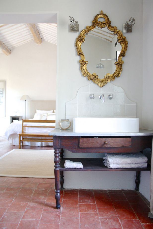 a bathroom with a sink, mirror and rugs on the floor in front of it